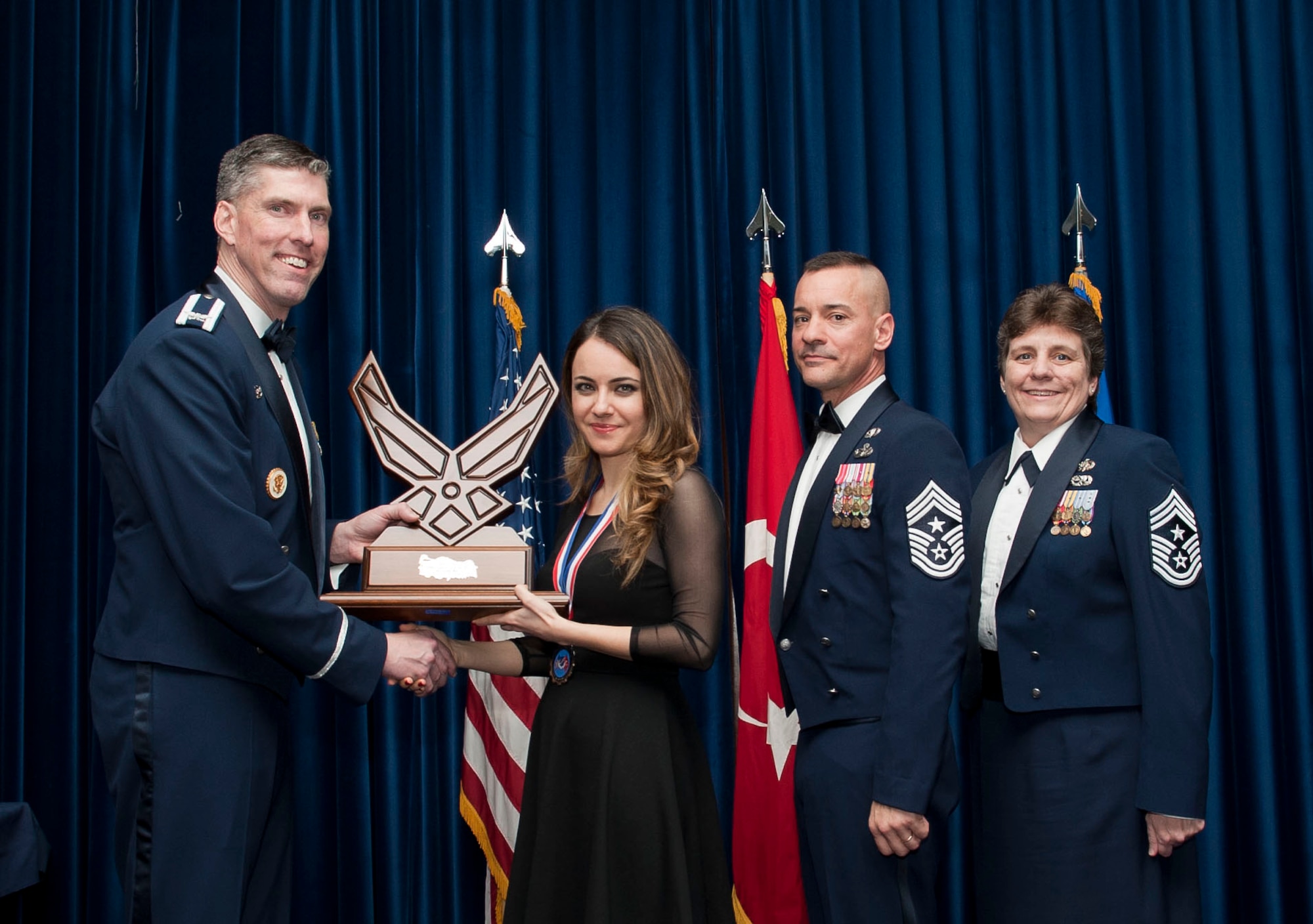 Begum Coban, 39th Comptroller Squadron, receives the 39th Air Base Wing Civilian of the Year Category I award from Col. Chris Craige, 39th Air Base Wing commander, during the 2012 Annual Awards Banquet Feb. 8, 2013, at Incirlik Air Base, Turkey. (U.S. Air Force photo by Senior Airman Daniel Phelps/Released)