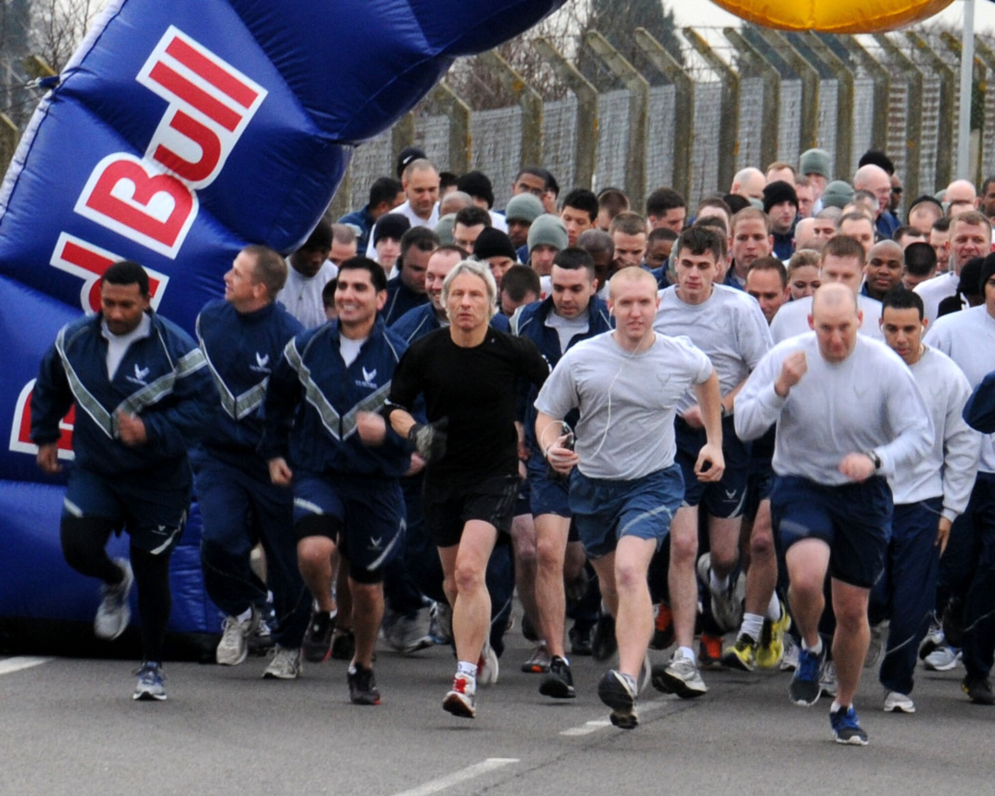 Team Mildenhall members take part in the monthly wing run Feb. 8, 2013, on Perimeter Road near the Hardstand Fitness Center on RAF Mildenhall, England. The run takes place on the first Friday of every month and is mandatory for all 100th Air Refueling Wing military personnel but tenant units and base ID card holders 13-years and older are welcome to attend. (U.S. Air Force photo by Gina Randall/Released)