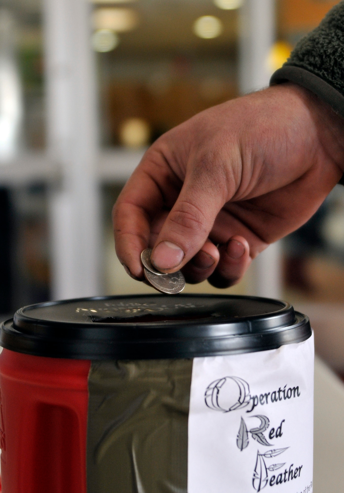 U.S. Air Force Airman 1st Class James Bradley, 35th Maintenance Squadron aerospace ground equipment technician, places a donation into a can at Misawa Air Base, Japan, Feb. 6, 2013. Red Feather Campaign donation sites are placed in high traffic areas around base. A Japanese charitable program, the Red Feather Campaign supports local social welfare programs. (U.S. Air Force photo by Tech. Sgt. Phillip Butterfield)