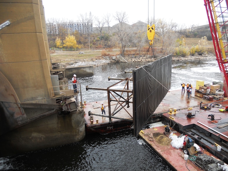 District maintenance and repair employees place a temporary dam, or cofferdam, on the Lower St. Anthony Falls Lock and Dam in Minneapolis during repairs in the fall of 2012.
