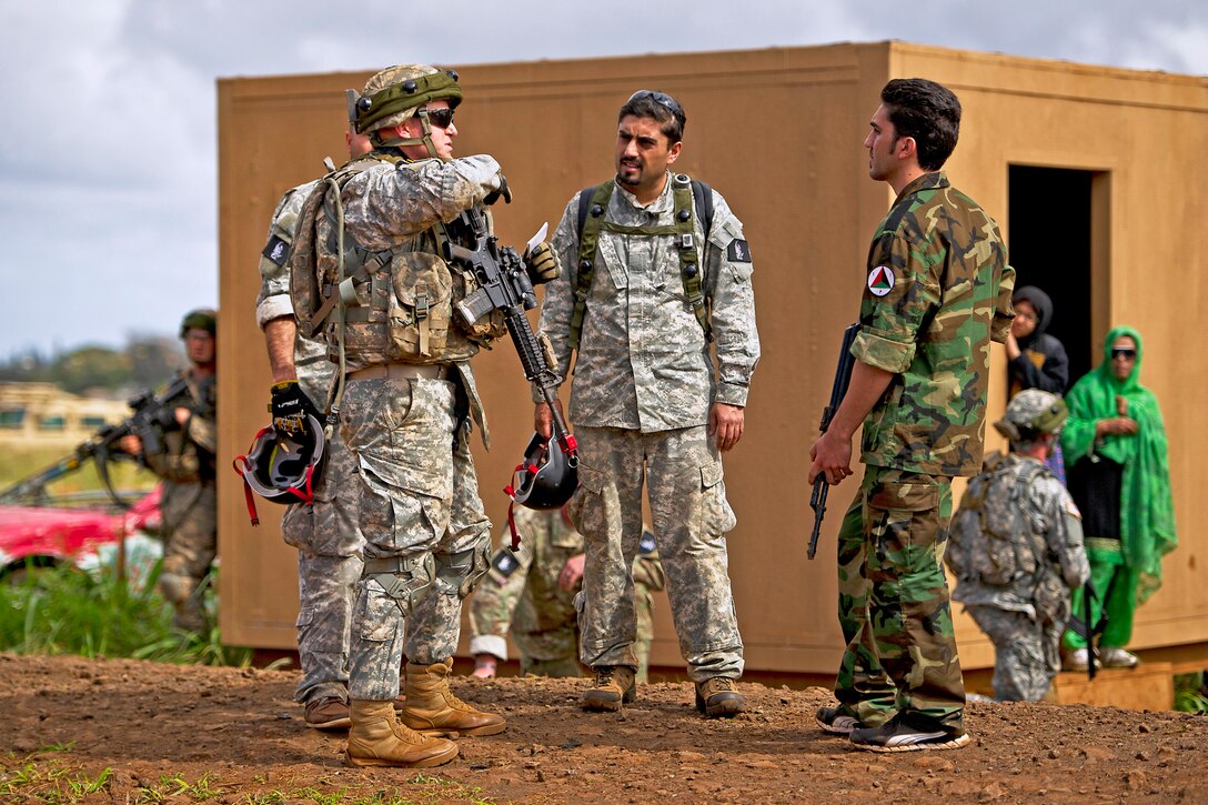 Army Capt. Kyle Burns, left, speaks with a role player acting as an Afghan soldier at a mock Afghan village during exercise Warrior Spear on Schofield Barrack in Wahiawa, Hawaii, Feb. 5, 2013. Burns is commander, 25th Infantry Division’s Company C, 1st Battalion, 14th Infantry Regiment, 2nd Stryker Brigade Combat Team.