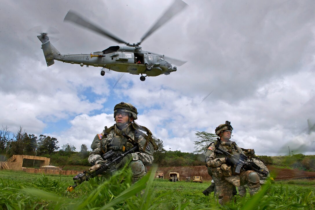 Soldiers secure a landing zone while a simulated casualty is hoisted aboard a Navy SH-60B Sea Hawk helicopter during joint hoist casualty evacuation training as part of exercise Warrior Spear on Schofield Barrack on Wahiawa, Hawaii, Feb. 5, 2013. The helicopter crew is assigned to Helicopter Anti-Submarine Squadron Light 37 from Marine Corps Air Station Kaneohe Bay, Hawaii.