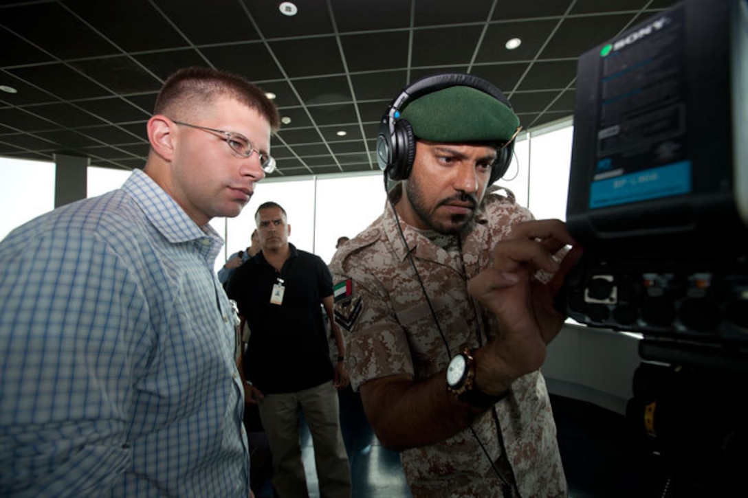 An United Arab Emirates service member adjusts a video camera with Cpl. Scott Achtemeier, U.S. Marine Corps Forces Central Command, Forward at Al Dhafra Air Base, UAE , as they tape flight operations during Exercise Leading Edge 13, Jan. 30, 2013. The multiple LE 13 Field Training Exercise events provided exercise participants opportunities to build relationships for the common cause behind the Proliferation Security Initiative. (U.S. Marine Corps photo by Sgt. Leon M. Branchaud)


