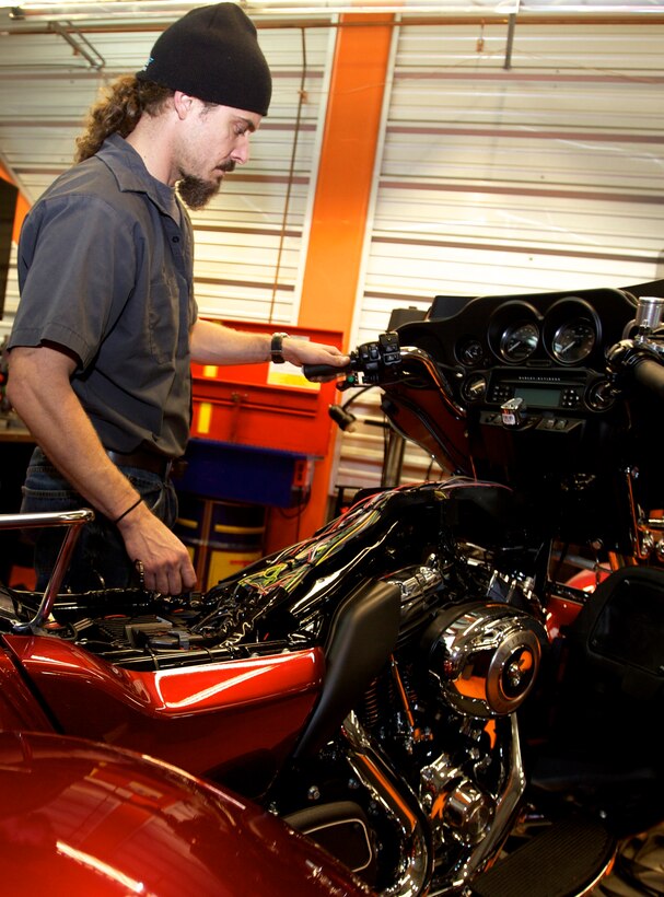 Jon Arnn, a mechanic for New River Harley Davidson, installs and tests the Kliktronic electronic gear actuator on the recently retired Sgt. Maj. Raymond H. Mackeyâ€™s custom Tri-Glide on Dec. 11. 2012, in Jacksonville N.C. Mackey, who is currently attached to Wounded Warrior Battalion, who has ridden motorcycles for more than 35 years, lost his legs in an improvised explosive device accident while serving with 3rd Battalion 10th Marine Regiment, in Helmand province Afghanistan in 2009.