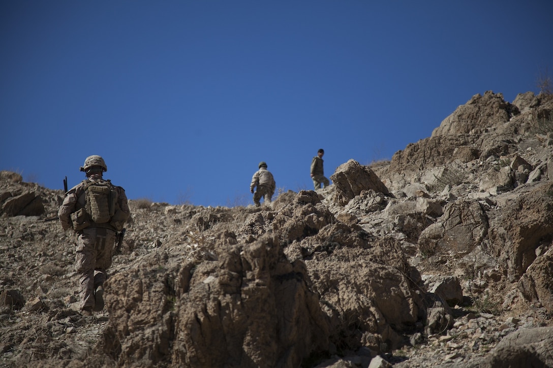 U.S. Marine Corps 1st Lt. William Kavanagh, left, company executive officer with Echo Company, 2nd Battalion, 7th Marines, Regimental Combat Team 7, climbs up a hill to conduct a site survey in Kajaki, Afghanistan, Feb. 8, 2013. The Marines of Echo Company are deployed to Afghanistan in support of Operation Enduring Freedom. (U.S. Marine Corps photo by Kowshon Ye/Released)