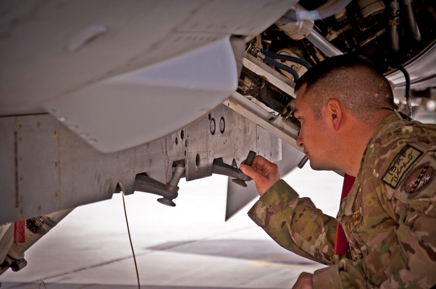 KANDAHAR AIRFIELD, Afghanistan -- Staff Sgt. William Bernhardt, 451st Expeditionary Aircraft Maintenance Squadron weapons load team chief, inspects an F-16 Fighting Falcon’s centerline pylon during a weapons load competition here Feb. 11. Bernhardt and two other Airmen made up a three-man weapons load crew and completed a four-phase evaluation. Their overall score will be put up against other scores of weapons load crews from their home station, Shaw Air Force Base, S.C. (U.S. Air Force photo/Senior Airman Scott Saldukas)