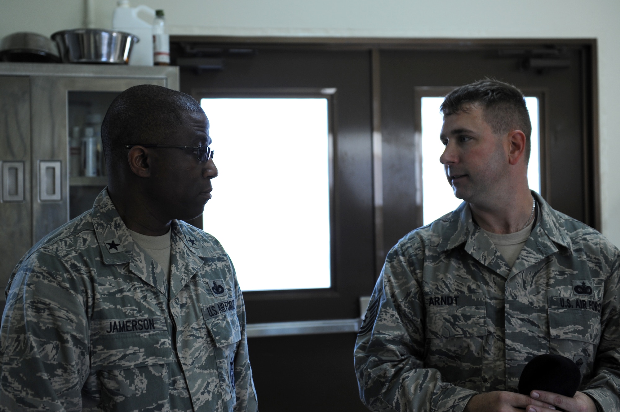 U.S. Air Force Tech. Sgt. Jonathan Arndt, 18th Security Forces Squadron military working dog handler, briefs Brig. Gen. Allen Jamerson, Director of Security Forces, Deputy Chief of Staff for Logistics, Installations and Mission Support, Headquarters U.S. Air Force, Washington, D.C., during a tour of the MWD kennels on Kadena Air Base, Japan, Feb. 12, 2013. Arndt explained how MWD handlers prepare food for the dogs and that the veterinarian comes to check on the dogs once a month. (U.S. Air Force photo/Airman 1st Class Hailey R. Davis)