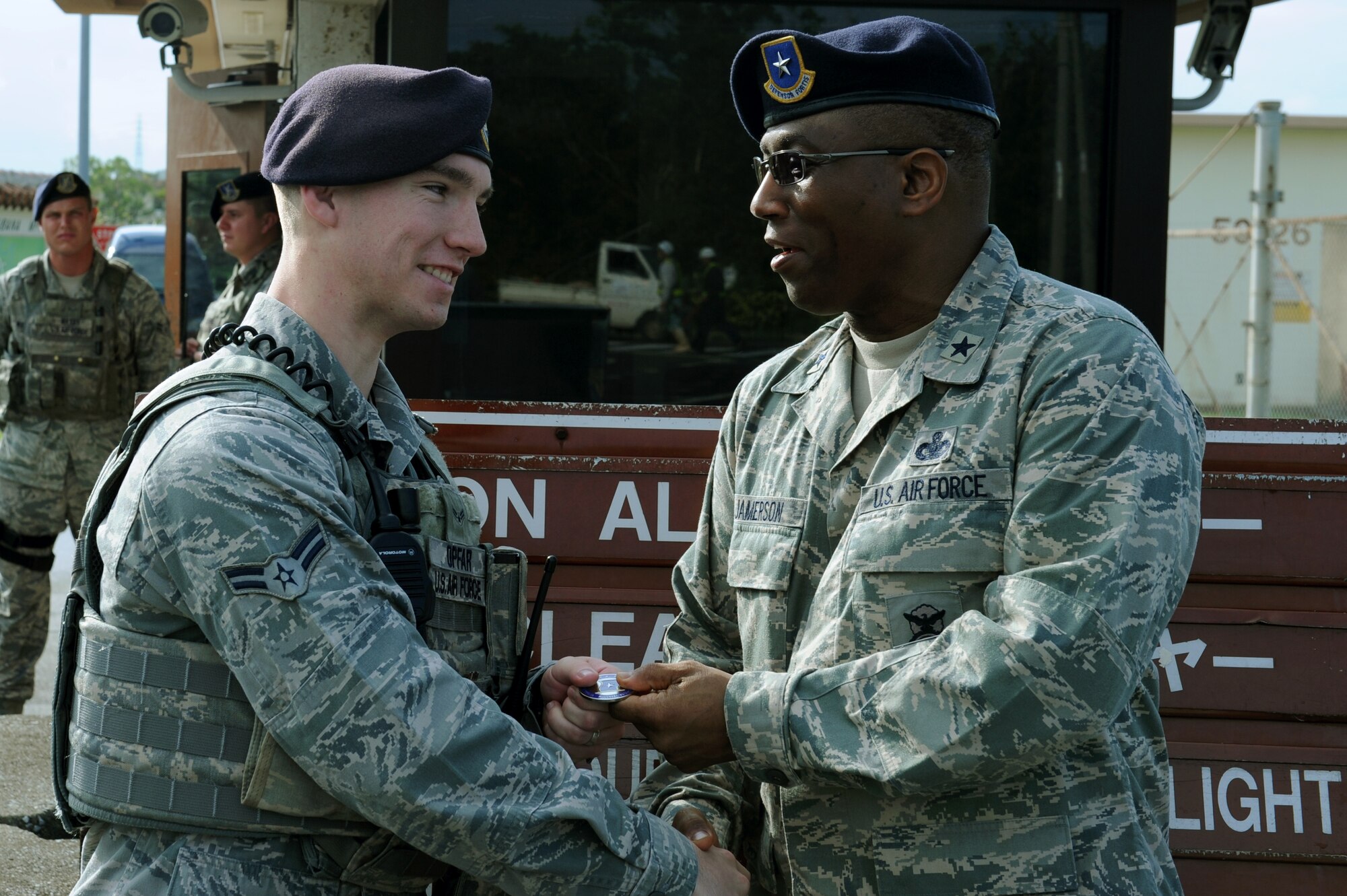 U.S. Air Force Brig. Gen. Allen Jamerson, Director of Security Forces, Deputy Chief of Staff for Logistics, Installations and Mission Support, Headquarters U.S. Air Force, Washington, D.C., coins Airman 1st Class Cody Opfar, 18th Security Forces Squadron response force member, on Kadena Air Base, Japan, Feb. 12, 2013. Opfar was recognized for his involvement as secretary of the Shogun Defenders Council, his volunteerism at Amelia Earhart Intermediate School, and his participation in numerous other base events. He is also a basic military training honor graduate and technical school distinguished graduate. (U.S. Air Force photo/Airman 1st Class Hailey R. Davis)