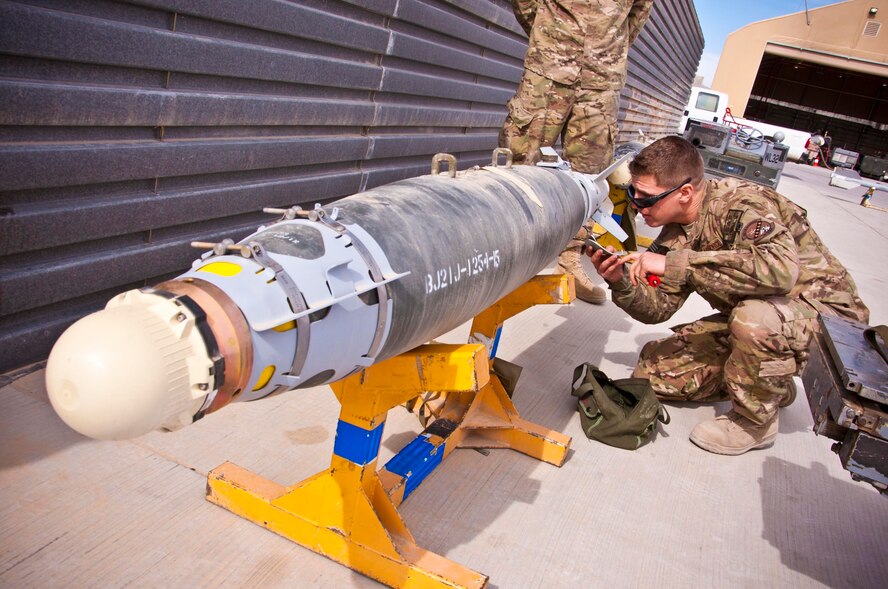 KANDAHAR AIRFIELD, Afghanistan -- Senior Airman Matthew Furey, 451st Expeditionary Aircraft Maintenance Squadron weapons load crew member, inspects a GBU-38 bomb during a weapons load competition here Feb. 11. Fernandez and two other Airmen made up a three-man weapons load crew and completed a four-phase evaluation. Their overall score will be put up against other scores of weapons load crews from their home station, Shaw Air Force Base, S.C.  (U.S. Air Force photo/Senior Airman Scott Saldukas)