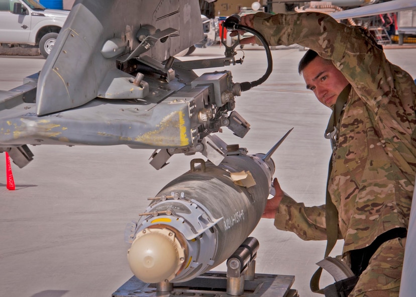 KANDAHAR AIRFIELD, Afghanistan -- Staff Sgt. William Bernhardt, 451st Expeditionary Aircraft Maintenance Squadron weapons load team chief, loads a GBU-38 bomb during a weapons load competition here Feb. 11. Bernhardt and two other Airmen made up a three-man weapons load crew and completed a four-phase evaluation. Their overall score will be put up against other scores of weapons load crews from their home station, Shaw Air Force Base, S.C. (U.S. Air Force photo/Senior Airman Scott Saldukas) 
