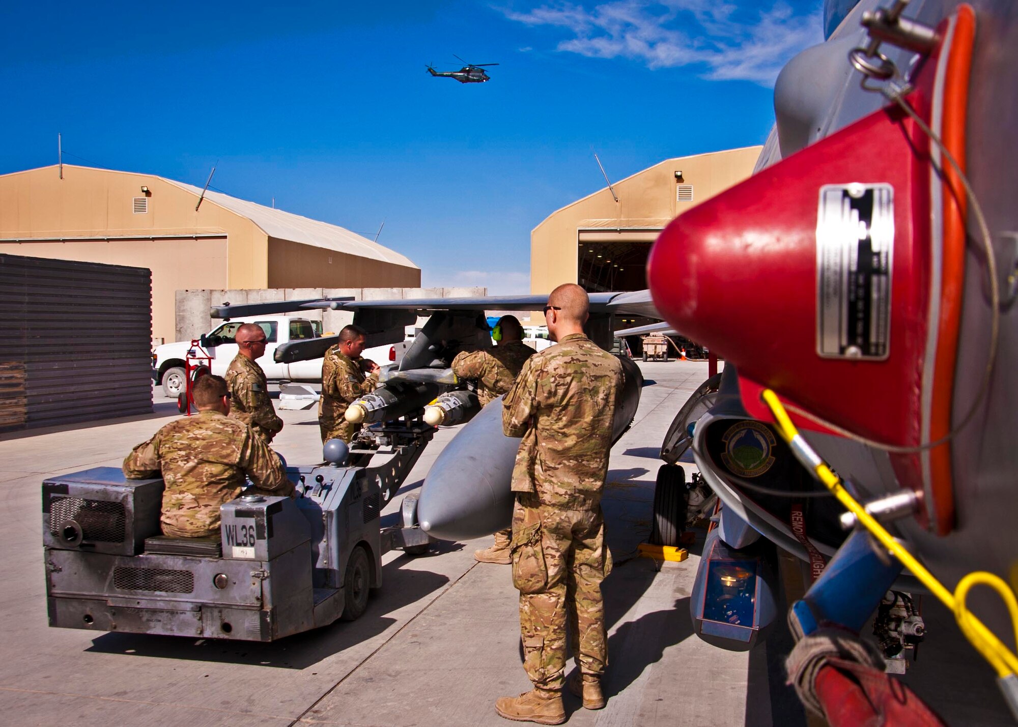 KANDAHAR AIRFIELD, Afghanistan – Three members of a weapons load crew loaded two GBU-38 bombs while two weapons loading competition evaluators watch here Feb. 11. The load crew completed a four-phase evaluation and their overall score will be put up against other scores of weapons load crews from their home station, Shaw Air Force Base, S.C. (U.S. Air Force photo/Senior Airman Scott Saldukas)