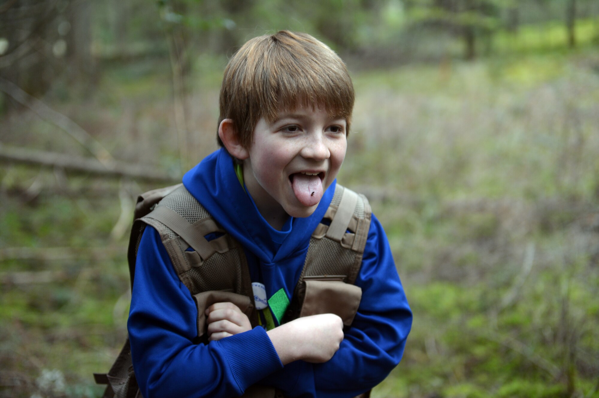 Carl Hess demonstrates his newly-acquired ability to survive by eating ants found in the surrounding area, Feb. 11, 2013, at Joint Base Lewis-McChord, Wash. During an event with the Make-a-Wish Foundation. U.S. Air Force survival, evasion, resistance and escape specialists from JBLM also taught Carl how to find water sources, how to build a shelter and how to start a fire. (U.S. Air Force photo/Staff Sgt. Jason Truskowski)
