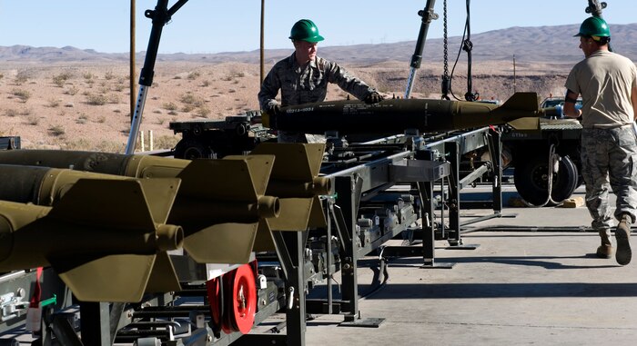 Airman 1st Class Justin Steele, 57th Maintenance Squadron munitions systems journeyman, and Staff Sgt. Thomas Pesek, 57th Maintenance Squadron munitions systems craftsman, off load Mk-82 bombs from a trailer onto a munitions assembly conveyor Feb. 11, 2013, Nellis Air Force Base, Nev. The bombs will be used for training to give pilots a real world feel for how to deploy the weapon, and the effects on the aircraft after the launch. (U.S. Air Force photo by Tech. Sgt. Taylor Worley) 