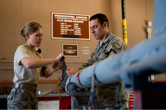 Staff Sgt. Brittney Benke, 57th Maintenance Squadron munitions systems craftsman, and Airman 1st Class Matthew Porto, 57th Maintenance apprentice, attach BSU-32 fins onto the guidance unit of a CATM 9M missile Feb. 7, 2013 at Nellis Air Force Base, Nev.  Benke and Porto are assigned to the Precision Guided Munitions shop, building and maintaining all air-to-air missiles, air-to-ground missiles, and computer control groups for guided bombs. (U.S. Air Force photo by Tech. Sgt. Taylor Worley)