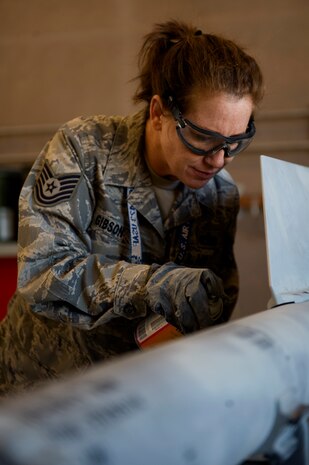 Tech. Sgt. Colleen Gibson, 57th Maintenance Squadron munitions systems craftsman, touches up paint during a 180 day inspection of a CATM 9M Feb. 7, 2013, Nellis Air Force Base, Nev. The Precision Guided Munitions shop is responsible for, building and maintaining all air-to-air missiles, air-to-ground missiles, and computer control groups for guided bombs. (U.S. Air Force photo by Tech. Sgt. Taylor Worley)