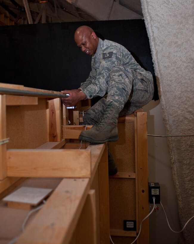 Tech. Sgt. Eugene Morgan, 28th Civil Engineer Squadron electrical systems technician, secures an electrical wire conduit pipe in place with a strap at the South Dakota Air and Space Museum, Box Elder, S.D., Jan. 30, 2013. This green energy project will take Airmen from 28th CES Electrical Shop roughly a month to complete. (U.S. Air Force photo by Airman 1st Class Alystria Maurer/Released)