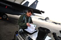 U.S. Air Force Capt. Justin Pavoni, 335th Fighter Squadron pilot, reviews pre-flight inspections manuals during exercise RAZOR TALON on Seymour Johnson Air Force Base, N.C., Feb. 7, 2013. RAZOR TALON is a monthly, large force exercise and joint-unit training opportunity to employ cutting edge operational concepts such as AirSea and Maritime Air Support on the Atlantic Coast. (U.S. Air Force photo by Staff Sgt. Andy M. Kin)