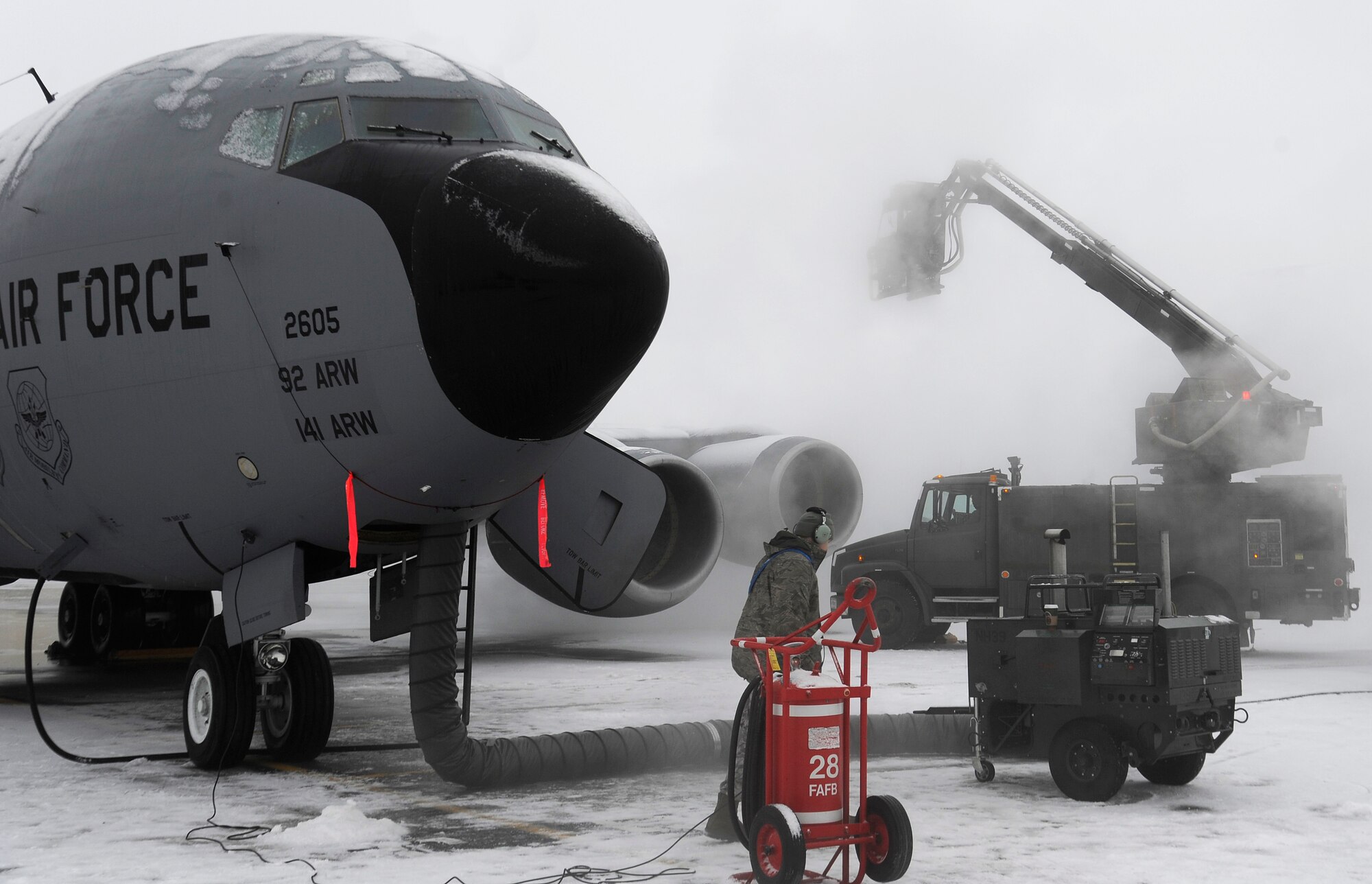 Members from the 92nd and 141st Aircraft Maintenance Squadrons apply de-icier and anti-ice chemicals to a KC-135 Stratontanker on the flight line at Fairchild Air Force Base, Wash., Jan. 24, 2013. It is essential to remove any snow or ice that may have formed on the aircraft as it can compromise the aircrafts performance during flight. (U.S. Air Force photo by Airman 1st Class Ryan Zeski)