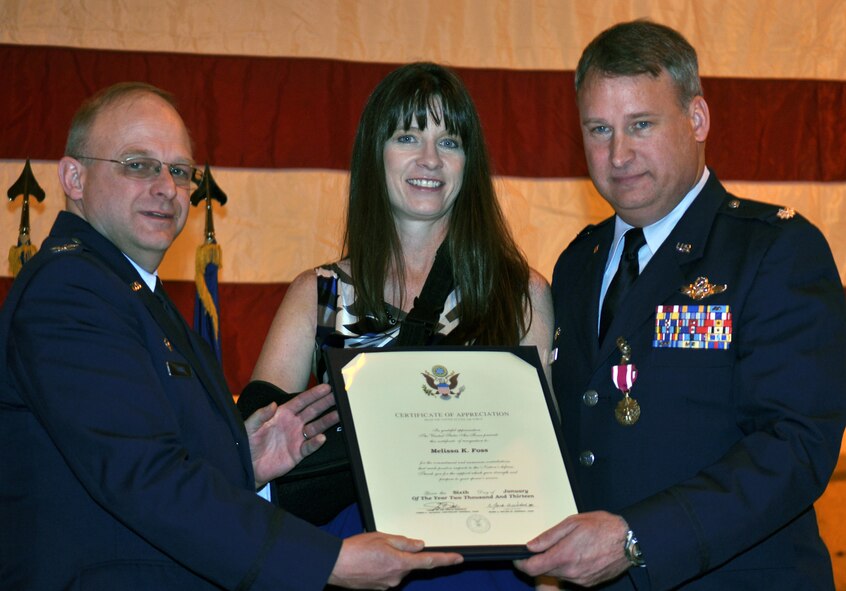 Col. Kurt Jones, left, 302nd Operations Group commander, and Lt. Col. Steven Foss, present Foss’ wife, Melissa, with a certificate of appreciation following the lieutenant colonel’s retirement ceremony Jan. 5 at Peterson Air Force Base, Colo. Foss, a native of Ft. Collins, Colo., retires as a master navigator with more than 4,500 flying hours. (U.S. Air Force photo/Tech. Sgt. Daniel Butterfield)