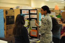 Senior Airman Chloe Ullah, 47th Medical Group public health technician, provides feedback to an elementary student for the elementary schools’ district science fair at the Del Rio Civic Center Del Rio, Texas, Feb. 7, 2013. Volunteers from Laughlin made up more than half of the judges for the 148 science fair projects and the little less than 200 children participating in the San Felipe Del Rio Consolidated Independent School District, district science fair. (U.S. Air Force photo/2nd Lt. David Tart)