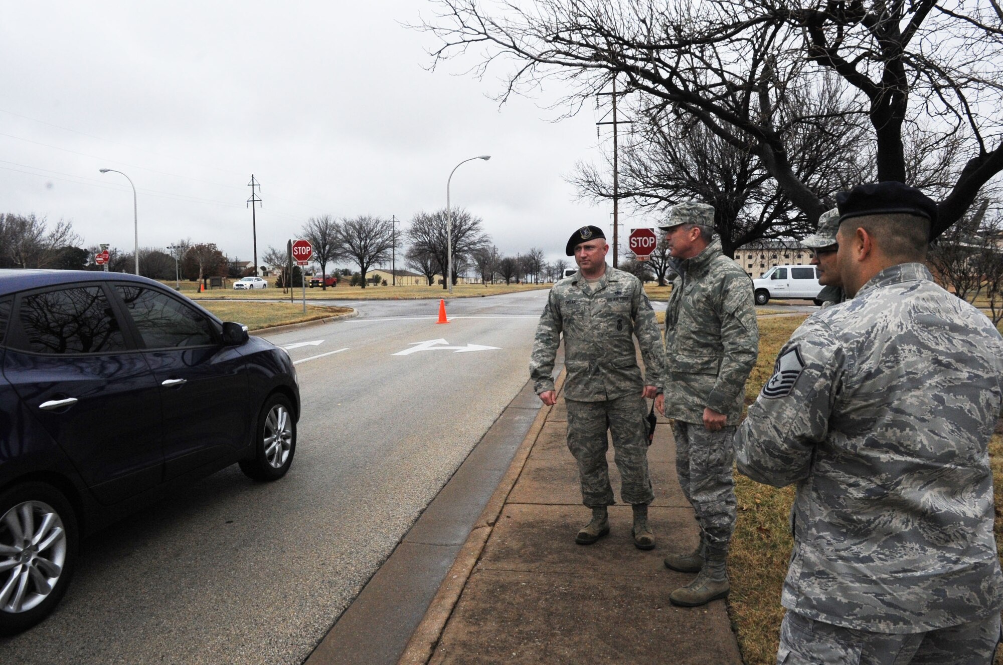 Tech. Sgt.Larry O'Rear (far left), 82nd Security Forces Squadron, briefs Brig. Gen. Michael Fantini, 82nd Training Wing commander, on the procedures for pulling over drivers caught talking on their unauthorized cell phones along Ave. E at Sheppard Air Force Base, Texas, on Feb. 12, 2013.  The 82nd SFS launched a traffic enforcement campaign aimed at catching distracted drivers in the act on the base. (U.S. Air Force photo/Dan Hawkins)