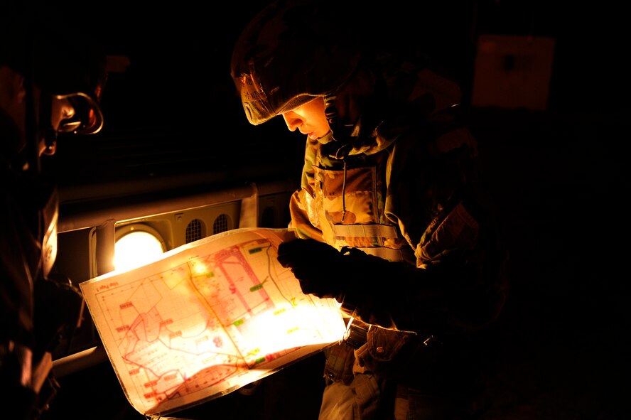 Airman 1st Class Joseph Pandolfo, 8th Communications Squadron, checks what zone he is in on a map before he marks a stanchion during exercise Beverly Bulldog 13-2 at Kunsan Air Base, Republic of Korea, Feb. 12, 2013. The stanchions list the necessary MOPP level precautions for Airmen as they enter or leave a chemical zone. (U.S. Air Force photo by Senior Airman Marcus Morris/Released)