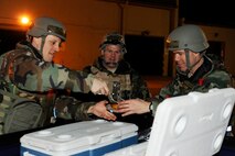 Staff Sgt. Joshua Strom, left, 8th Fighter Wing chaplain assistant, and Capt. Kevin Hudson, 8th FW Chaplain, serve hot dogs to the Airmen working out in the cold weather during exercise Beverly Bulldog 13-2 at Kunsan Air Base, Republic of Korea, Feb. 12, 2013. Visiting with the Airmen allows the Chaplain to help boost morale and to give them support and guidance through the exercise. (U.S. Air Force photo by Senior Airman Marcus Morris/Released)