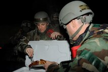 Staff Sgt. Joshua Strom, left, 8th Fighter Wing chaplain assistant, and Capt. Kevin Hudson, 8th FW Chaplain, serve hot dogs to the Airmen working out in the cold weather during exercise Beverly Bulldog 13-2 at Kunsan Air Base, Republic of Korea, Feb. 12, 2013. Visiting with the Airmen allows the Chaplain to help boost morale and to give them support and guidance through the exercise. (U.S. Air Force photo by Senior Airman Marcus Morris/Released)