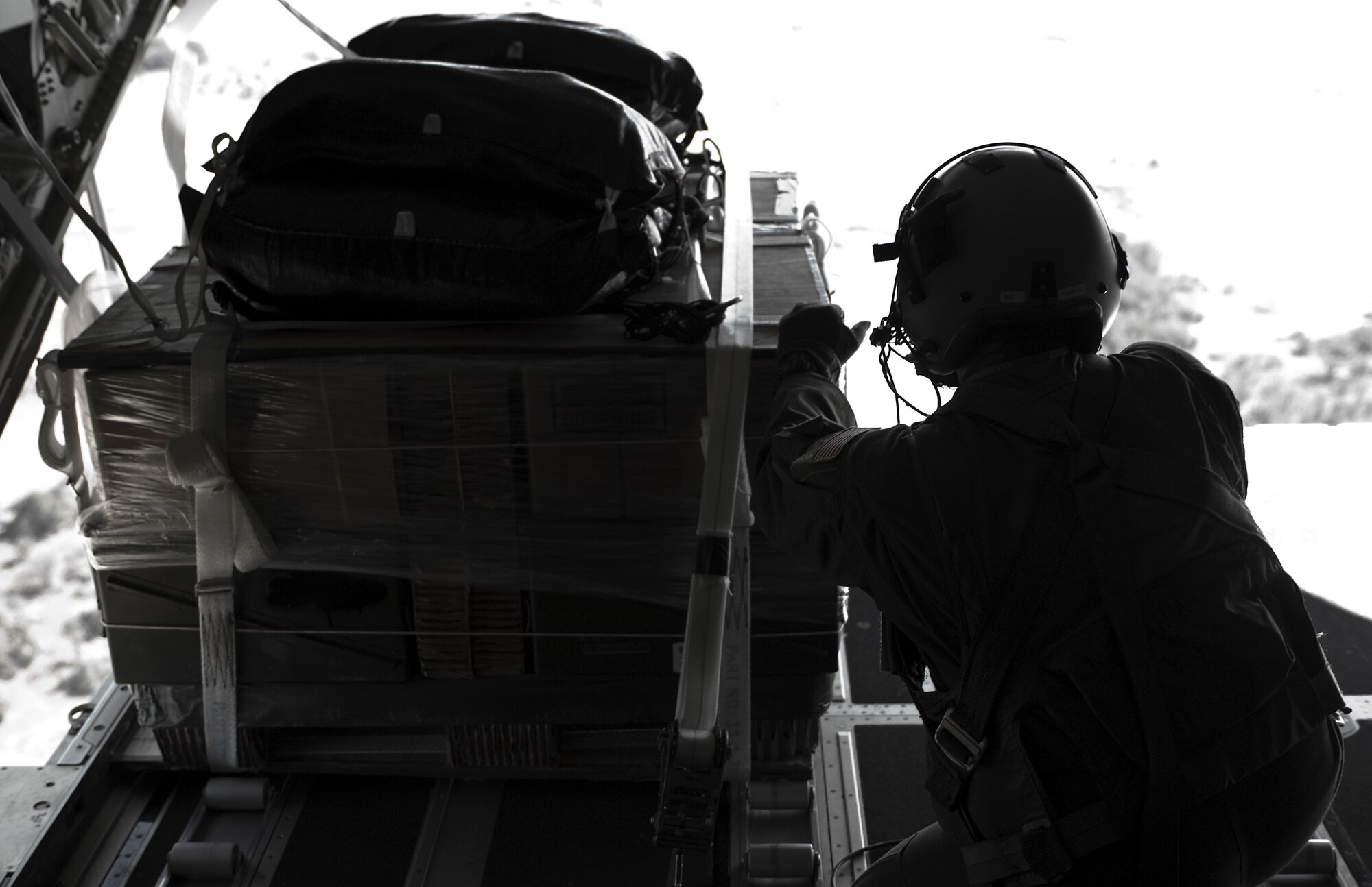 Senior Airman Elizabeth Patton, 39th Airlift Squadron, prepares to release a low-cost-low-altitude cargo bundle during a training exercise Feb. 7, 2013, at Fort Hood, Texas. The LCLA airdrops are a special container delivery system, designed to be used and discarded rather than turned in and reused.  This method saves the receiver trouble, and the low altitude helps with accuracy and staying under the radar of the enemy. (U.S. Air Force photo by Airman 1st Class Kylsee Wisseman/Released)