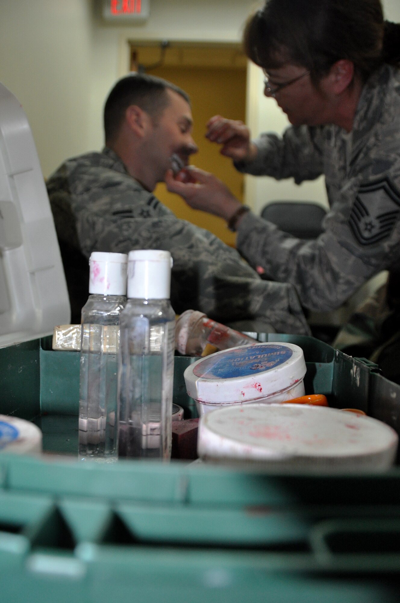 Senior Master Sgt. Tracey House, 51st Medical Support Squadron superintendent, uses moulage equipment to paint a simulated wound on Airman 1st Class Jordan Bells, 51st Munitions Squadron ammunition apprentice during operational readiness exercise Beverly Bulldog 13-02, Feb. 13, 2013 at Osan Air Base, Republic of Korea. Bells acted as a role player who was blown up in a vehicle by improvised explosive device.