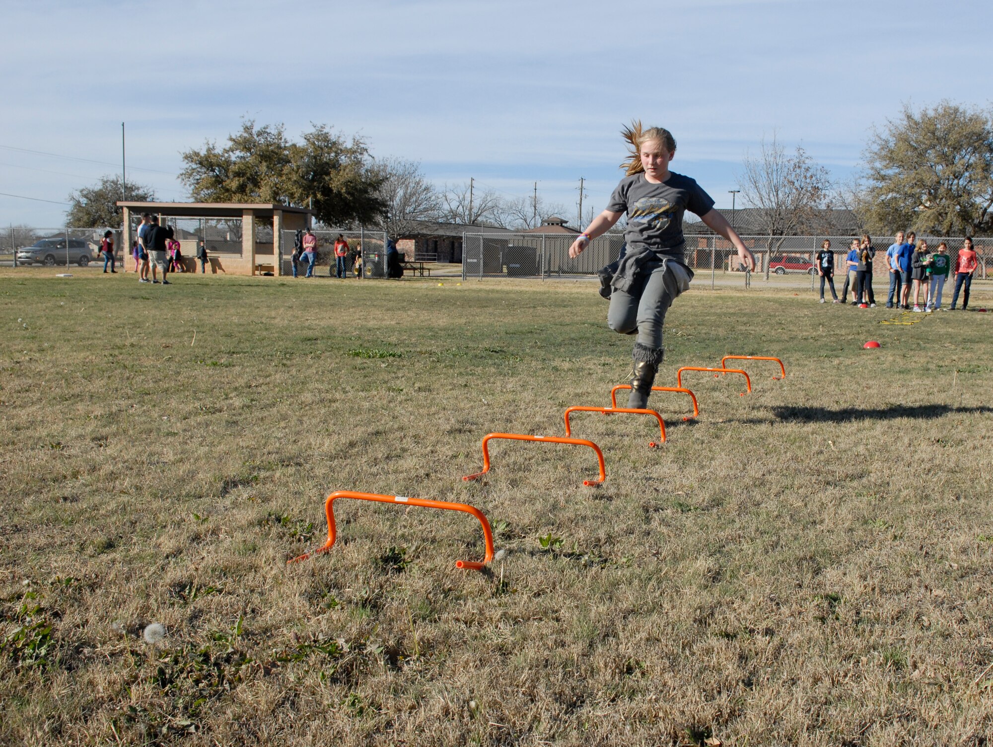 GOODFELLOW AIR FORCE BASE, Texas—A girl runs over hurdles during the fifth annual Kids’ Fun Day at the Little League baseball field, Feb. 8. Hosted by the Youth Center, the event promotes children’s health and nutrition. (U.S. Air Force photo/Lou Czarnecki)