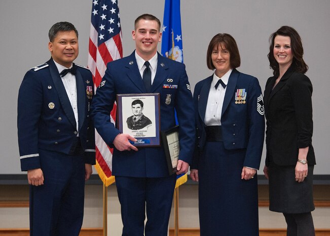 Senior Airman Michael Mullis, 341st Civil Engineer Squadron, center, receives the John L. Levitow award at the Airman Leadership School Class 13-C graduation banquet.  Shown presenting the award are Col. H.B. Brual, 341st Missile Wing commander; Chief Master Sgt. Regina Knipp, 341st Maintenance Group superintendant; and Alaina Barrow, Park University campus director.  The Levitow award is the highest honor given at all levels of enlisted professional military education.  The graduation banquet was held Feb. 5 at the Grizzly Bend.  (U.S. Air Force photo / Beau Wade)
