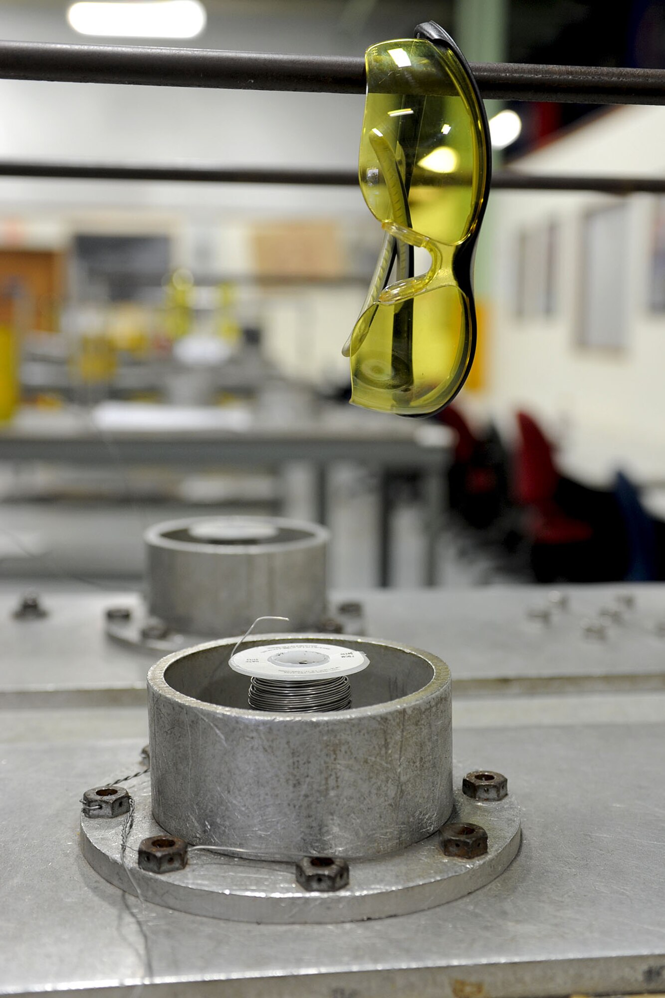 Eye protection glasses rest on a bar above a hardware training device in a 1st Battalion, 210th Aviation Regiment, A Company Advanced Individual Training classroom at Fort Eustis, Va., Jan. 30, 2013. The device is used to train students on how to safely secure nuts and bolts, as well as properly use safety wire while repairing aircraft components. (U.S. Air Force photo by Staff Sgt. Ashley Hawkins/Released)