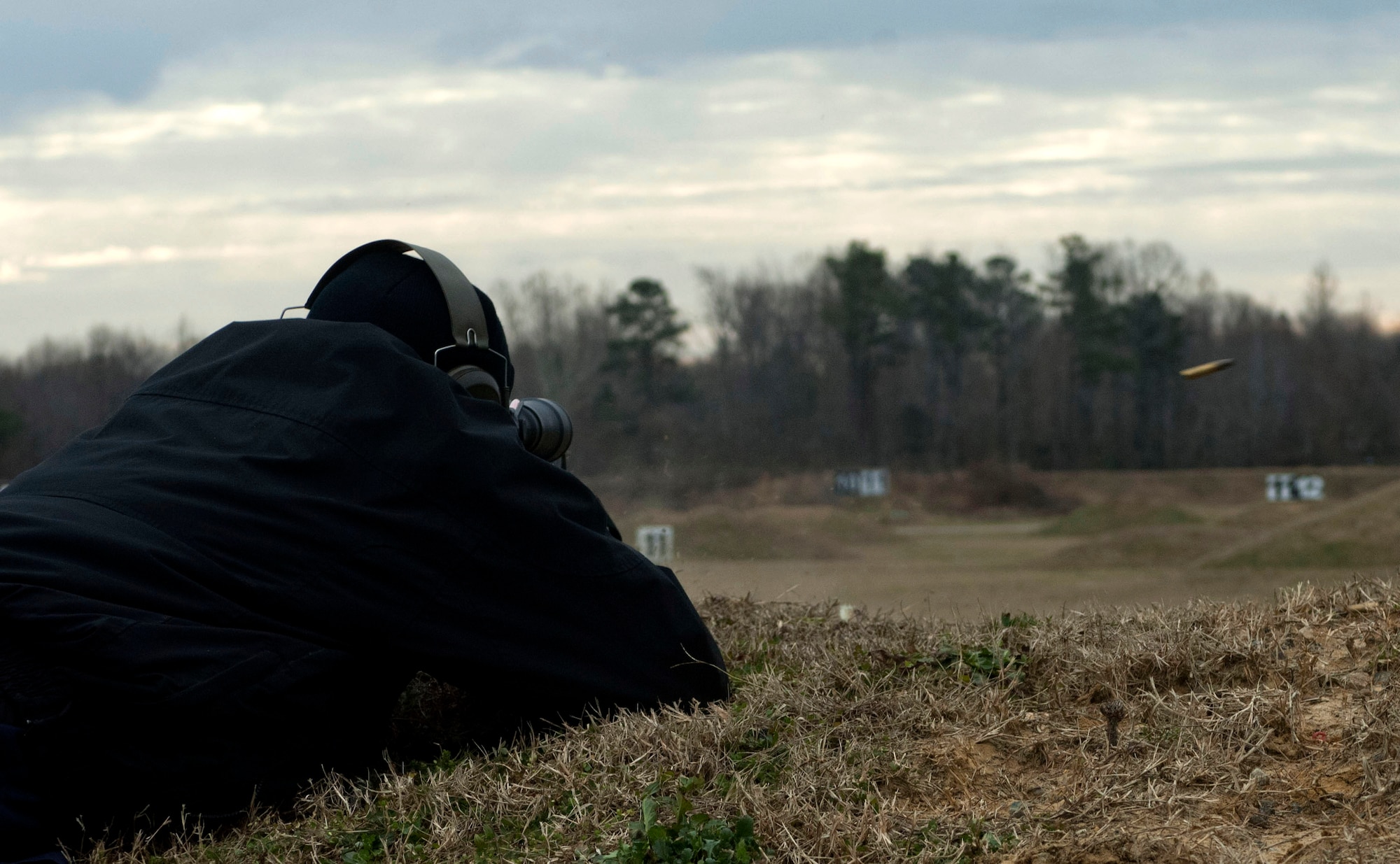 Police Lt. Michael Arndt, 733rd Security Forces Squadron training officer, fires at a target to demonstrate capabilities of the redesigned Location of Miss and Hit System at Range 3 on Fort Eustis, Va., Feb. 5, 2013. The system uses acoustic sensors to detect supersonic projectiles within a two-meter radius of a target. The sensors at the target emplacement, then relay the results to an Android-based tablet at the firing point, enabling individuals, trainers and coaches to recognize and identify errors and correct them in a more defined and accurate manner. (U.S. Air Force photo by Airman 1st Class R. Alex Durbin/Released)