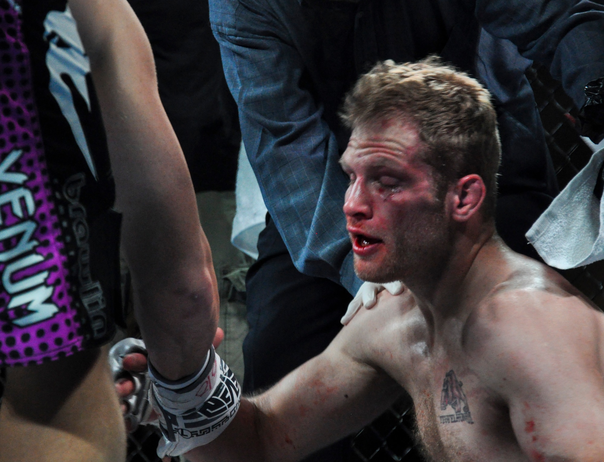 A bloodied Reed O’Malley congratulates his opponent Todd “Captain America” Meredith after a brutal battle Feb. 9, 2013, at Buckley MMA Fight Night. Meredith won by technical knockout in the first round after delivering bone-crushing blows to O’Malley’s face from the mount position. (U.S Air Force photo by Staff Sgt. Nicholas Rau/Released)   