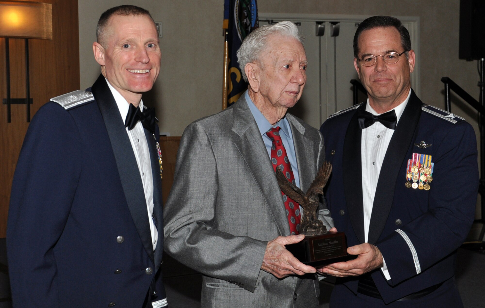 Brig. Gen. Kenneth D Lewis, director of Air Force Reserve Plans, Programs, and Requirements, and Col. Mark S. Larson, commander of the 931st Air Refueling Group, McConnell Air Force Base, Kan., present Adrian Marlin with a trophy as a token of appreciation for Marlin's service in the Army Air Corps during World War II, Feb. 9, 2013.  Marlin served as a tail gunner on a B-17 Flying Fortress during the war.  He and his aircrew survived a crash landing in 1944.  Marlin was Larson's guest of honor at the banquet.  (U.S. Air Force photo by Master Sgt. Brannen Parrish)