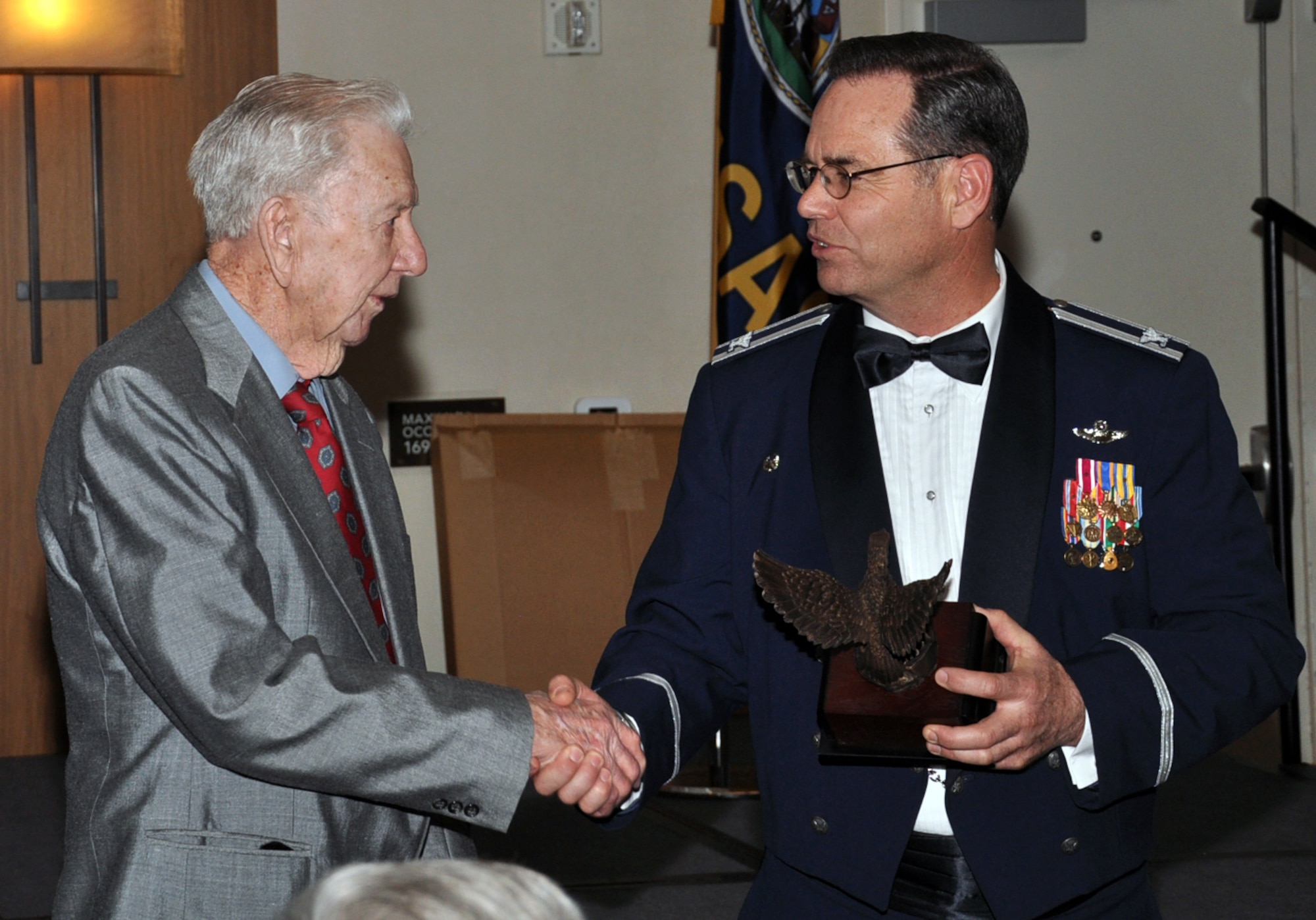 Col. Mark S. Larson, commander of the 931st Air Refueling Group, McConnell Air Force Base, Kan., presents Adrian Marlin with a trophy as a token of appreciation for Marlin's service in the Army Air Corps during World War II, Feb. 9, 2013.  Marlin served as a tail gunner on a B-17 Flying Fortress during the war.  He and his aircrew survived a crash landing in 1944.  Marlin was Larson's guest of honor at the banquet.  (U.S. Air Force photo by Master Sgt. Brannen Parrish)