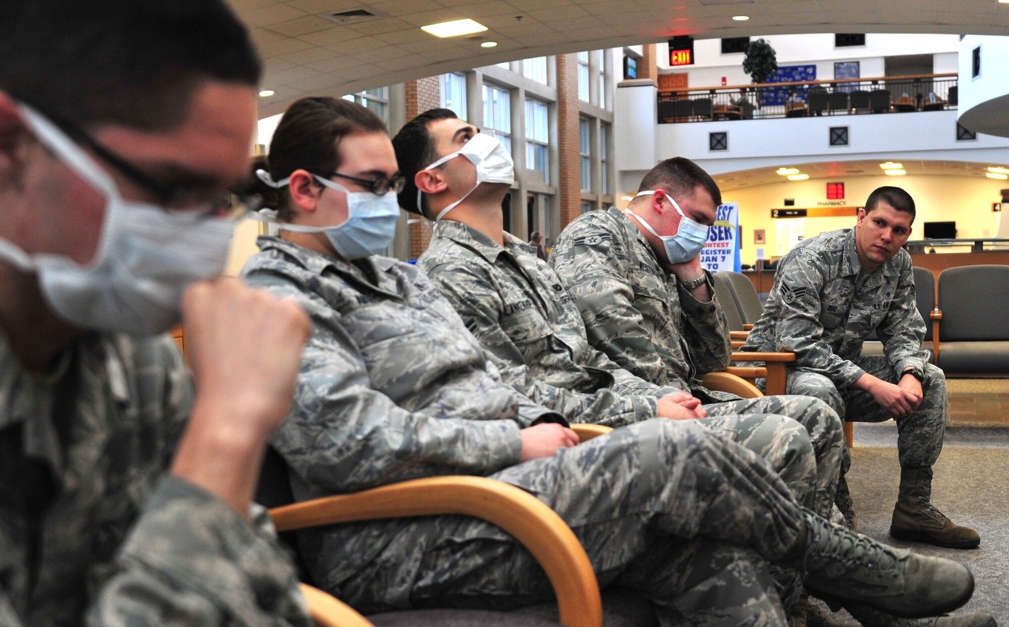 In this staged photo, Senior Airman Osniel Diaz, 42nd Medical Group public health professional, peers down a line of sick service members during this flu season. To date, the clinic has issued more than 6,500 influenza vaccines for this season’s outbreak. (U.S. Air Force illustration by Senior Airman Christopher Stoltz)
