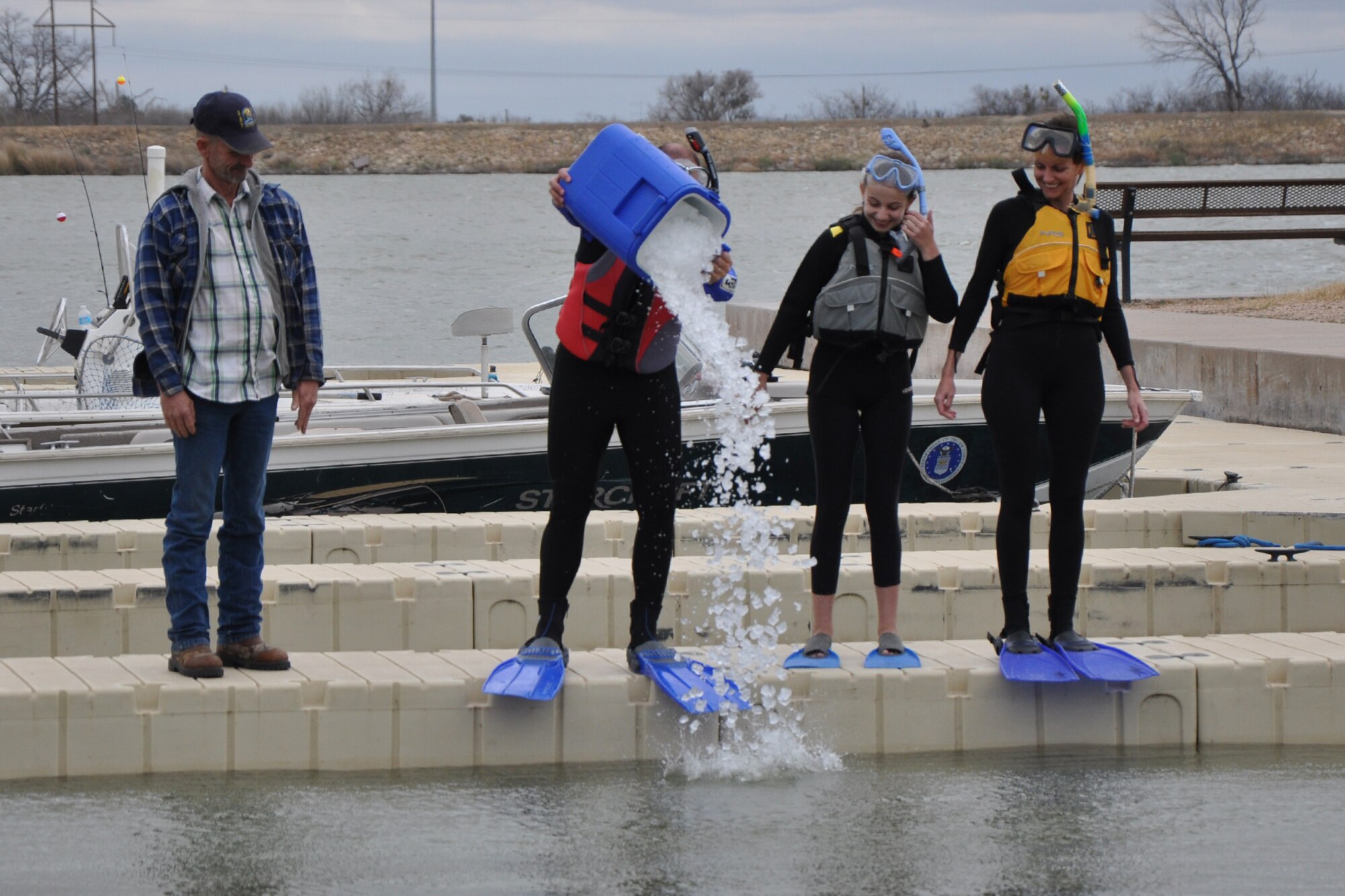 SAN ANGELO, Texas – Col. Mark Damiano, 17th Training Wing Commander, pours a bucket of ice into Lake Nasworthy before jumping into the water at the 2013 Goodfellow Outdoor Recreation Camp Polar Bear Plunge, Feb. 9. Damiano, along with his wife and daughter. were the first plungers this year. (U.S. Air Force photo/ Staff Sgt. Robert Smith)