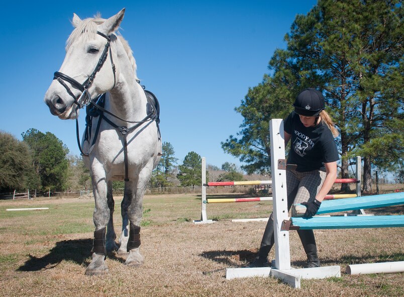 U.S. Air Force Staff Sgt. Stacey Chastain, 23d Wing Judge Advocate military justice paralegal, raises a jump fence outside a stable in Valdosta, Ga., Feb. 3, 2013. Unlike cross-country courses, these fences will fall if hit, limiting the chance of injury to rider or horse. (U.S. Air Force photo by Senior Airman Jarrod Grammel/Released)
