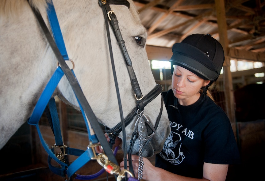 U.S. Air Force Staff Sgt. Stacey Chastain, 23d Wing Judge Advocate military justice paralegal, puts a bridle on her horse, Klein, at a stable in Valdosta, Ga., Feb. 3, 2013. Chastain has been riding horses since she was 6 years old. (U.S. Air Force photo by Senior Airman Jarrod Grammel/Released)
