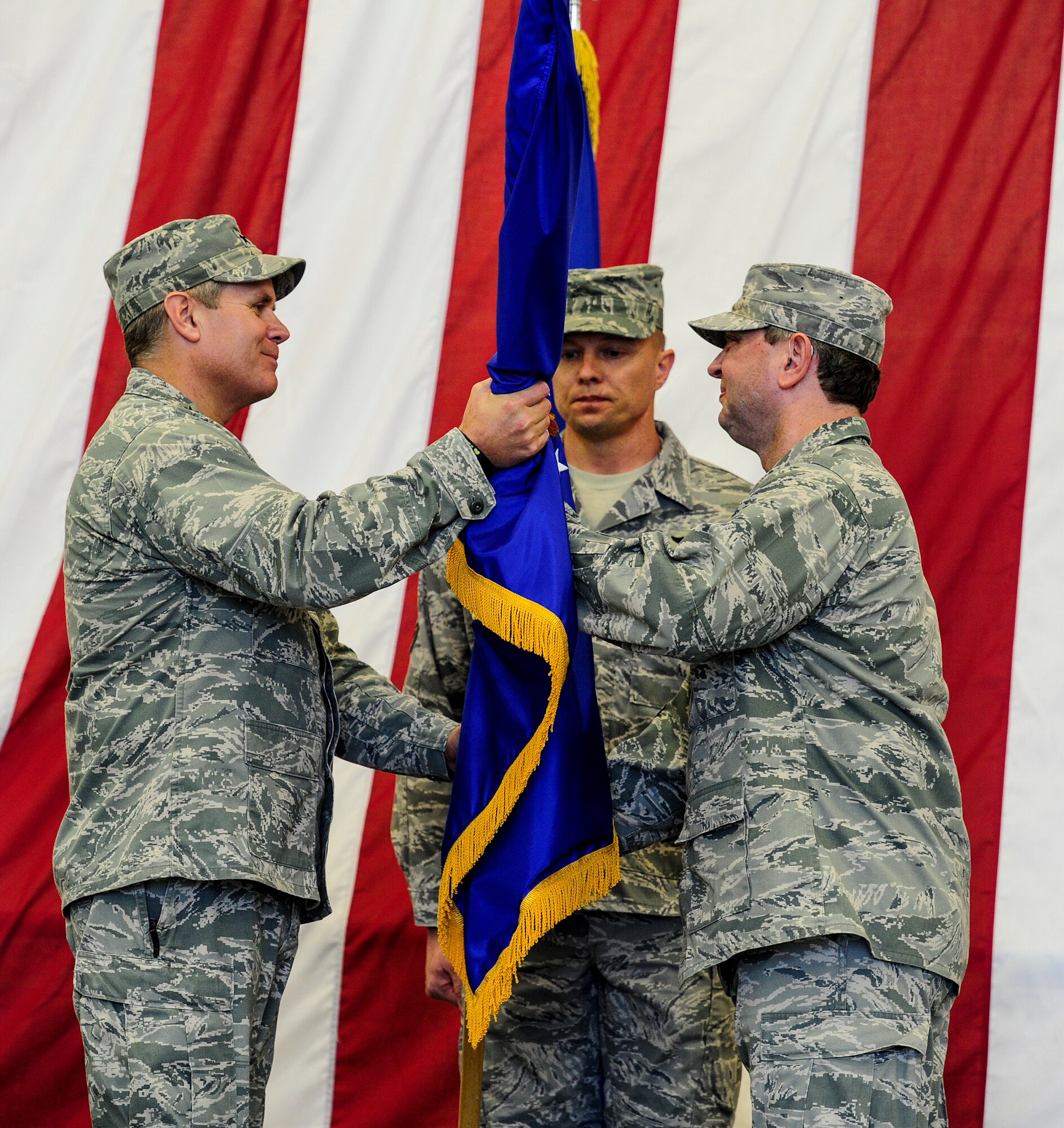 U.S. Air Force Lt. Gen. Eric Fiel, commander of Air Force Special Operations Command, left, takes the Air Force Special Operations Training Center flag from Col. William Andersen, commander of AFSOTC, right, during a ceremony held on Duke Field, Fla., Feb. 11, 2013. The ceremony was held for the deactivation of AFSOTC and the activation and assumption of command of the Air Force Special Operations Air Warfare Center. (U.S. Air Force photo/Airman 1st Class Christopher Callaway)