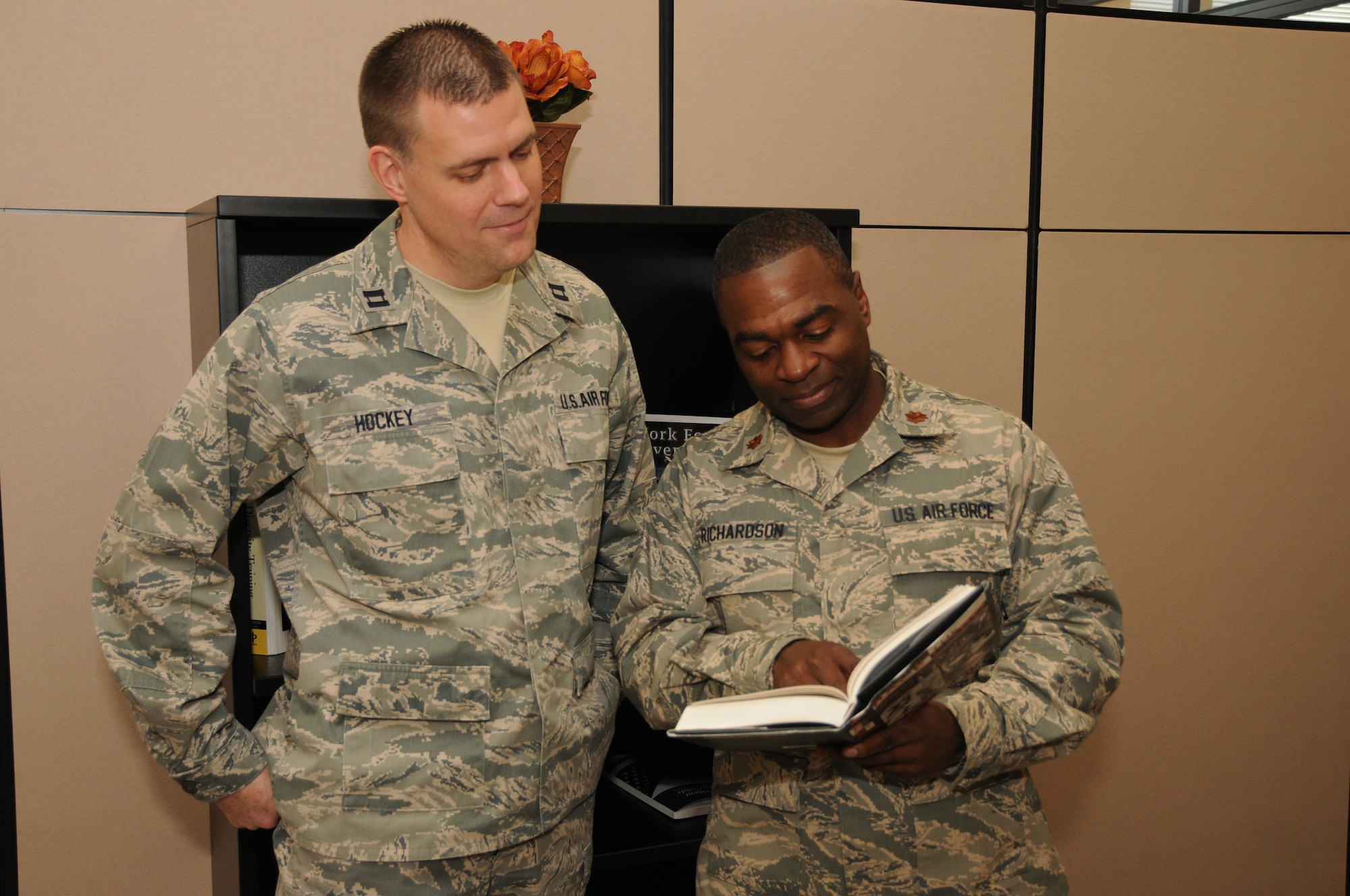 New York Air National Guard Maj. Gary Richardson (right), 174th Attack Wing Equal Opportunity Director and Capt. James Hockey, Equal Opportunity Officer, read a passage from a book on equal opportunity at the Joint Health and Wellness Center on Hancock Field Air National Guard Base, Syracuse, NY February 3, 2013. Richardson is preparing for his job as the Equal Opportunity service liaison for the National Guard Component. (Photo by NY Air National Guard Senior Airman Duane Morgan/Released)