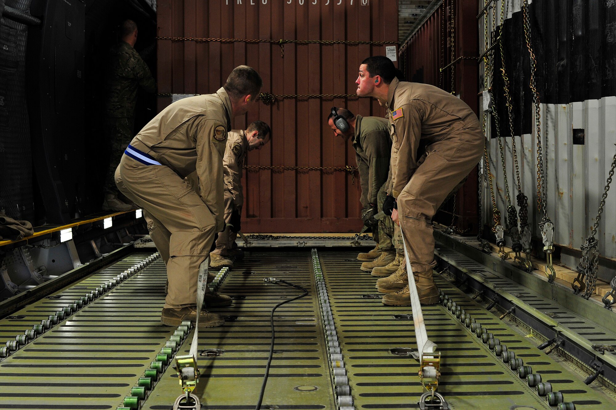 CAMP MARMAL, Afghanistan – U.S. Air Force Airmen use the leverage of straps to pull a cargo pallet train into position on a C-5M Super Galaxy here Jan. 28, 2013. The 621st sent a contingency response team to Mazar-e-sharif Afghanistan to provide en-route command and control and communications support in support of a U.S. transportation command intermodal movement of two U.S. Army Combat Aviation Brigades. (U.S. Air Force photo by Tech Sgt. Parker Gyokeres)