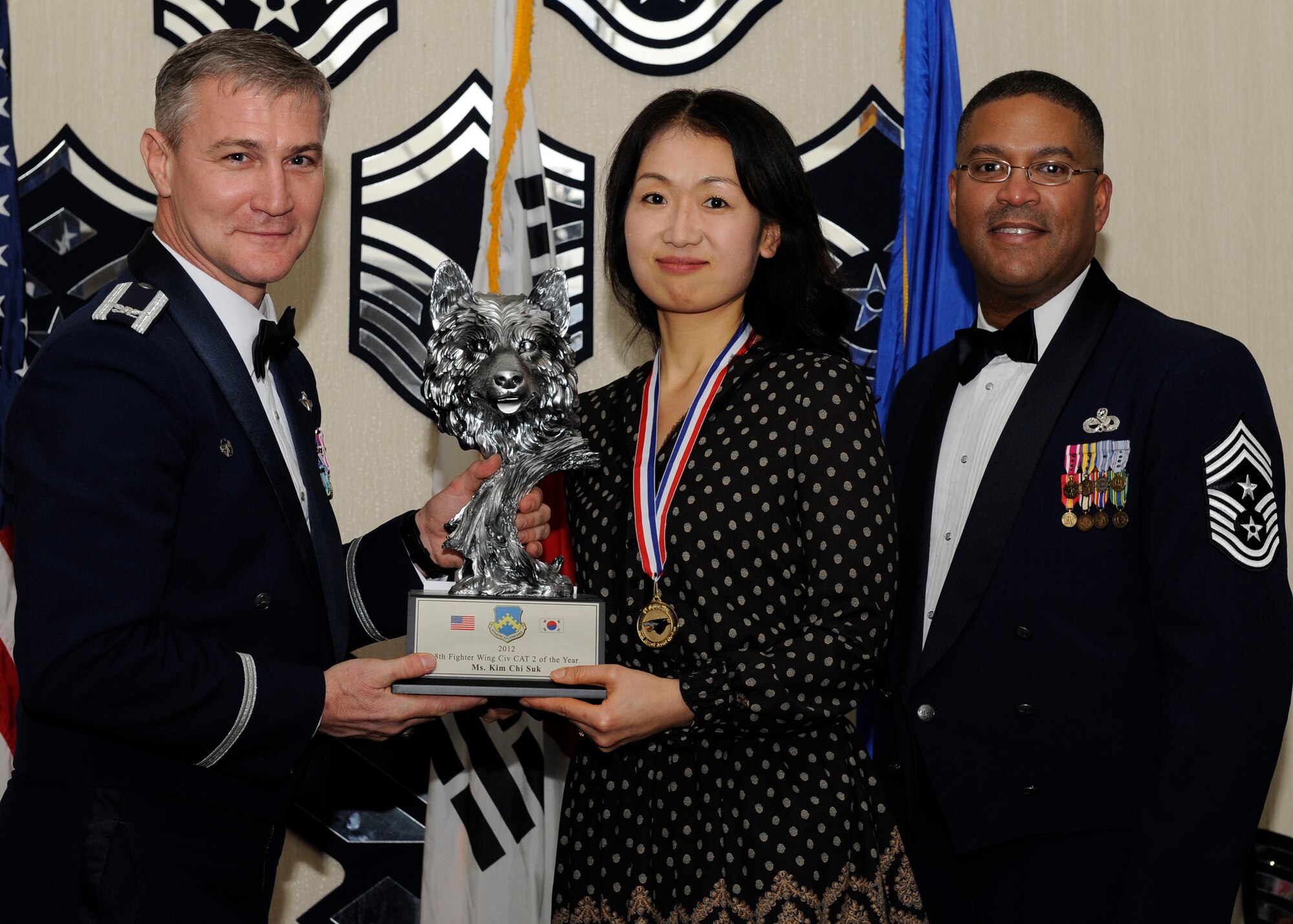 Ms. Kim Chi Suk, 8th Civil Engineer Squadron, receives the 8th Fighter Wing Civilian Category 2 of the Year award from Col. John Pearse, 8th FW commander, at Kunsan Air Base, Republic of Korea, Feb. 1, 2013. The award winners will continue on to compete in the 7th Air Force awards. (U.S. Air Force photo by Senior Airman Marcus Morris/Released)