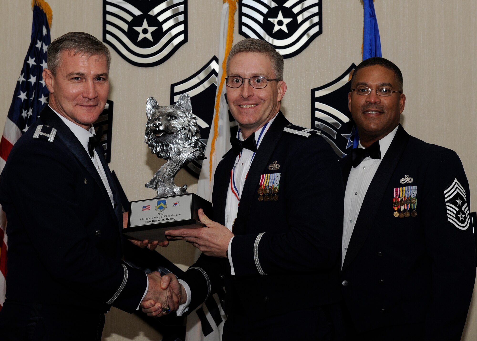 Capt. Duane Denney 8th Maintenance Squadron munitions flight commander, receives the 8th Fighter Wing Company Grade Officer of the Year award from Col. John Pearse, 8th FW commander, at Kunsan Air Base, Republic of Korea, Feb. 1, 2013. The award winners will continue on to compete in the 7th Air Force awards. (U.S. Air Force photo by Senior Airman Marcus Morris/Released)