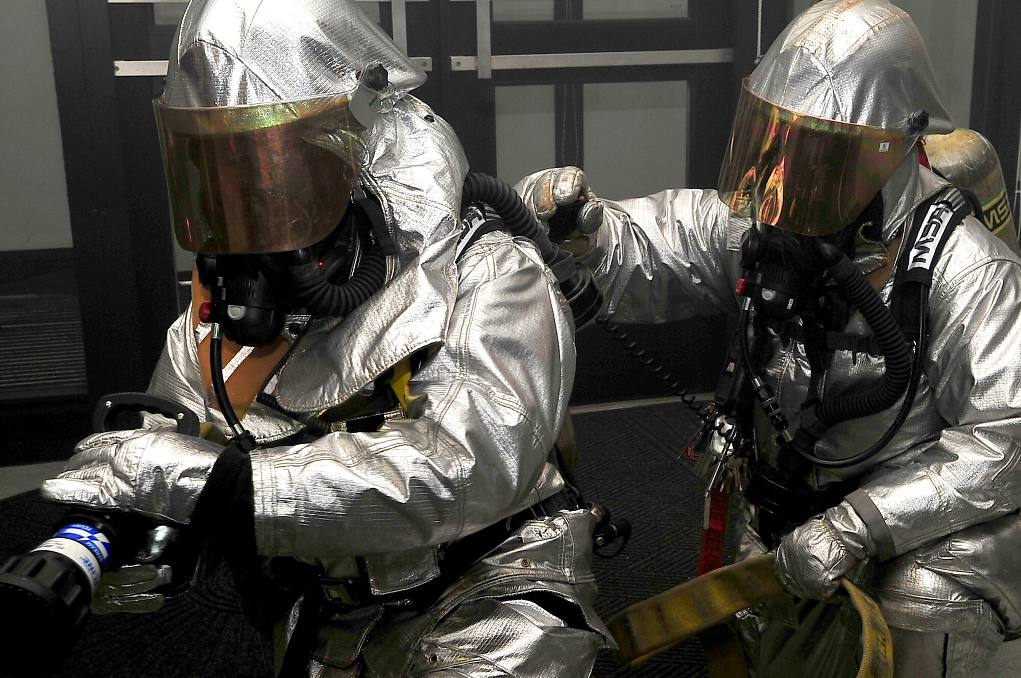 Senior Airman Juan Duarte and Staff Sgt. Jacob Barrey, members of the 51st Civil Engineer Squadron fire department engage a mock fire at the 51st Logistics Readiness Squadron vehicle operations facility Exercise Beverly Bulldog 13-02 at Osan Air Base, Republic of Korea, Feb. 12, 2013. Duarte and Barry use the buddy concept to increase safety and survivability when entering an austere environment. (U.S. Air Force photo/Tech. Sgt. Raymond Mills) 