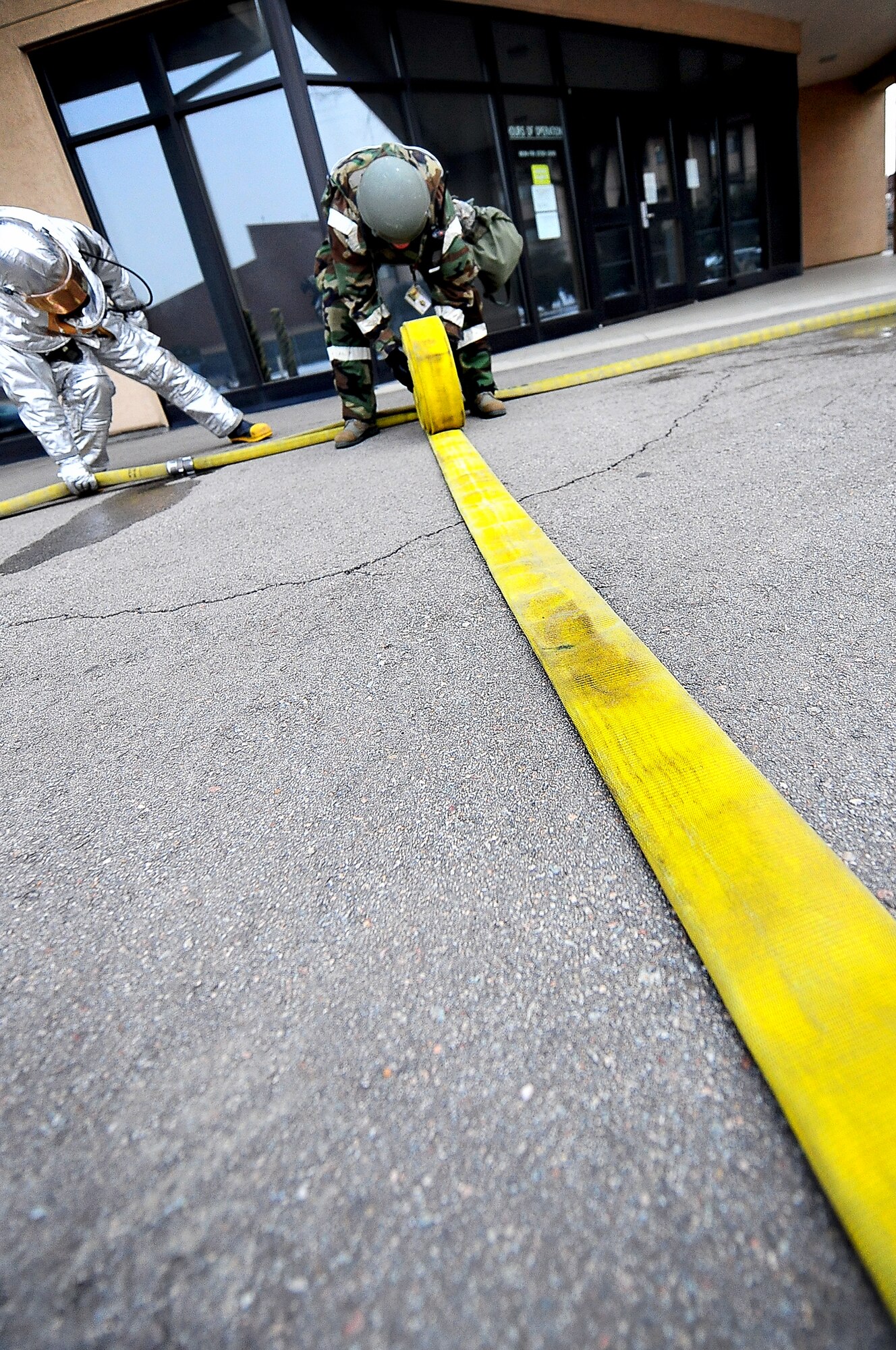 Tech. Sgt. Christopher Gunn, a fire fighter with the 51st Civil Engineer Squadron, rolls up a fire hose after conducting a training scenario as part of an operational readiness exercise, Beverly Bulldog 13-02, at Osan Air Base, Republic of Korea, Feb. 12, 2013. These types of exercises help Airmen train in a heightened state of readiness in order to provide combat ready forces for close air support, air strike control, counter air, interdiction, theater airlift, and communications in the defense of the Republic of Korea. (U.S. Air Force photo/Staff Sgt. Sara Csurilla)