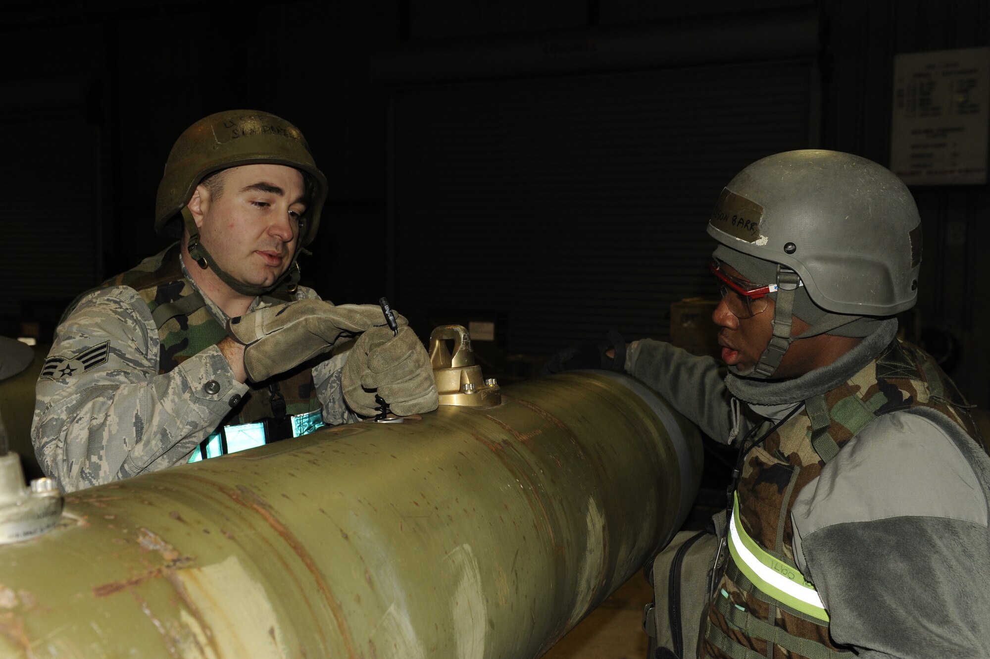 Senior Airman Daniel Lamb, 8th Maintenance Squadron munitions inspector, trains Airman 1st Class Barry Wilson, 8th MXS, how to assemble a Joint Direct Attack Munition during exercise Beverly Bulldog 13-2 at Kunsan Air Base, Republic of Korea, Feb. 12, 2013. The Airmen can assemble more than 80 JDAMs per 12-hour shift. (U.S. Air Force photo by Senior Airman Marcus Morris/Released)