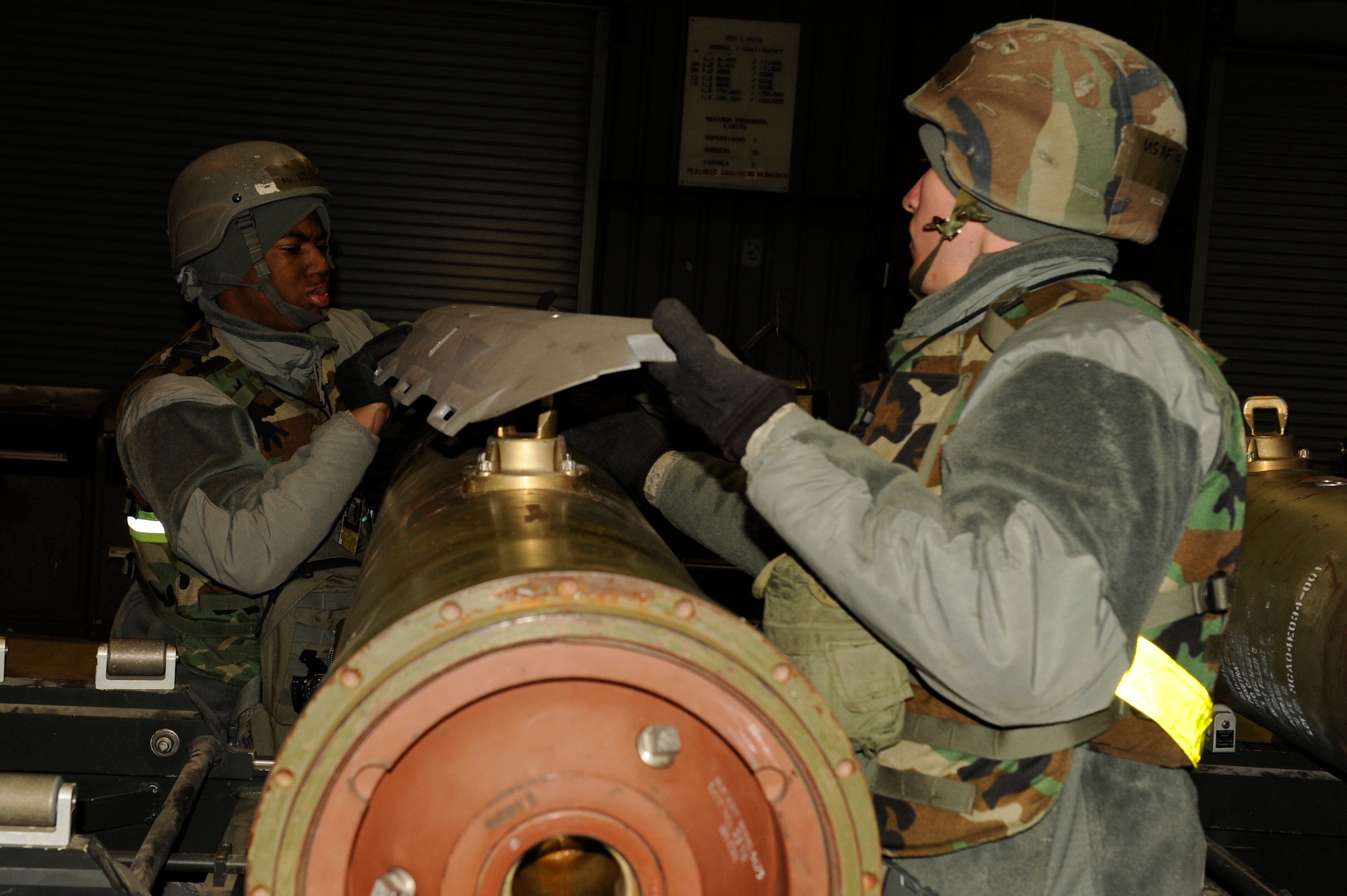 Airman 1st Class Barry Wilson, left, and Michael Okonski, 8th Maintenance Squadron, places a panel onto a Joint Direct Attack Munition during exercise Beverly Bulldog 13-2 at Kunsan Air Base, Republic of Korea, Feb. 12, 2013. The Airmen can assemble more than 80 JDAMs per 12-hour shift. (U.S. Air Force photo by Senior Airman Marcus Morris/Released)